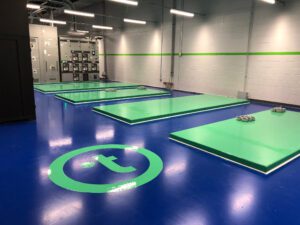 a fitness room with four green mats